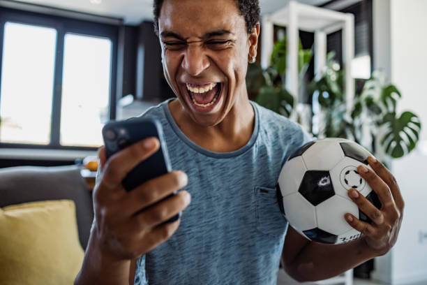 Male football fan yelling during football game. He is happy because he got money. Online betting.